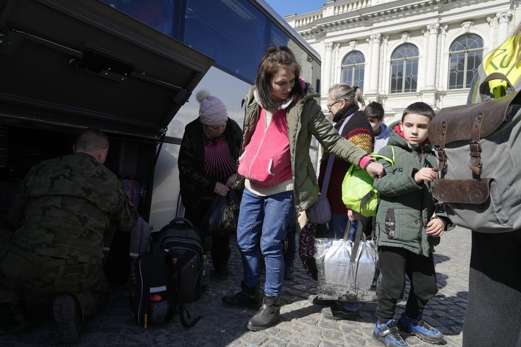 Ukrainian refugees with children board a bus in Przemysl, Poland, on Tuesday. Photo: AP