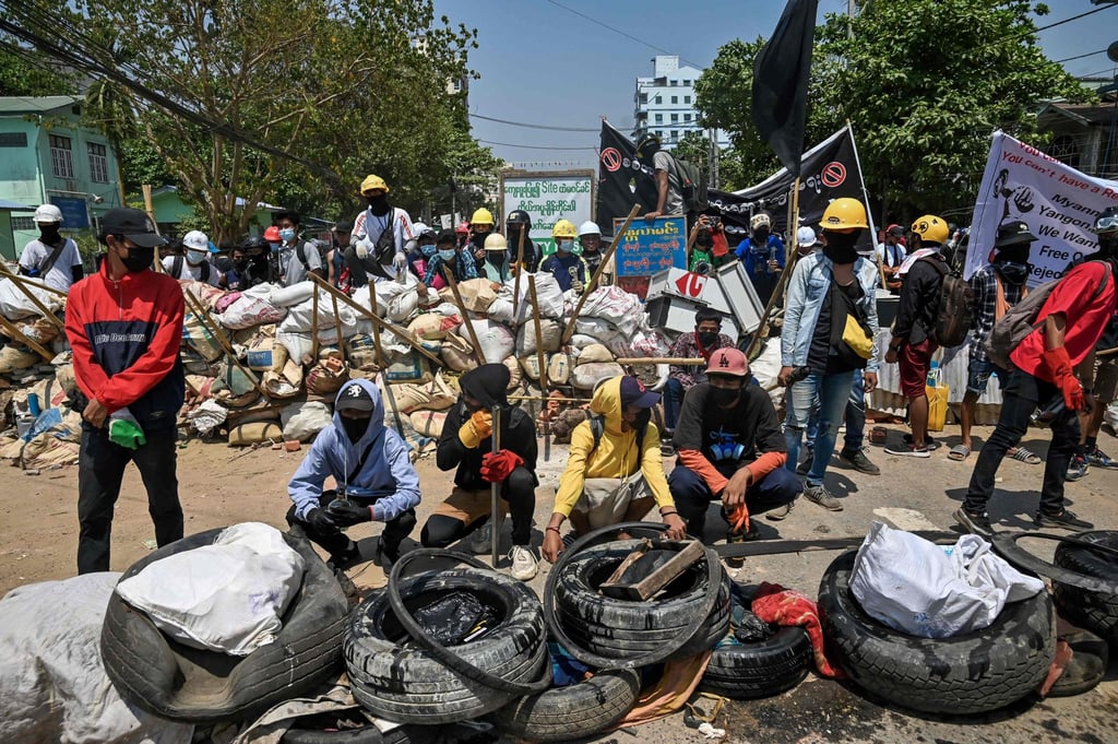 Protesters gather by a barricade during a crackdown by security forces on demonstrations against the military coup in Yangon in March 2021. Photo: STR/AFP