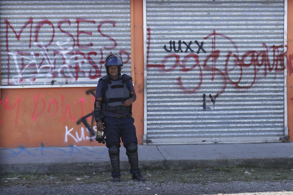 A Solomon Islands policeman stands outside a business in Chinatown, Honiara, in November 2021, following violence sparked by concerns about increasing links with China. Photo: AP
