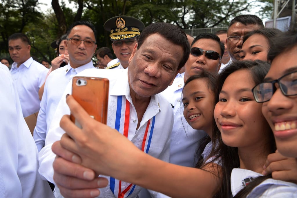 Philippines’ President Rodrigo Duterte poses for a selfie with students. Photo: AFP Philippines’ President Rodrigo Duterte poses for a selfie with students. Photo: AFP