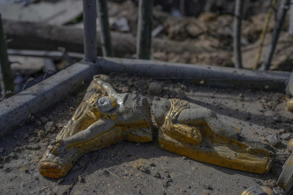 A small destroyed monument of Jesus, is seen in front of a house hit by Russian rocket at Zelenyi Hai village between Kherson and Mykolayiv. Photo: AFP