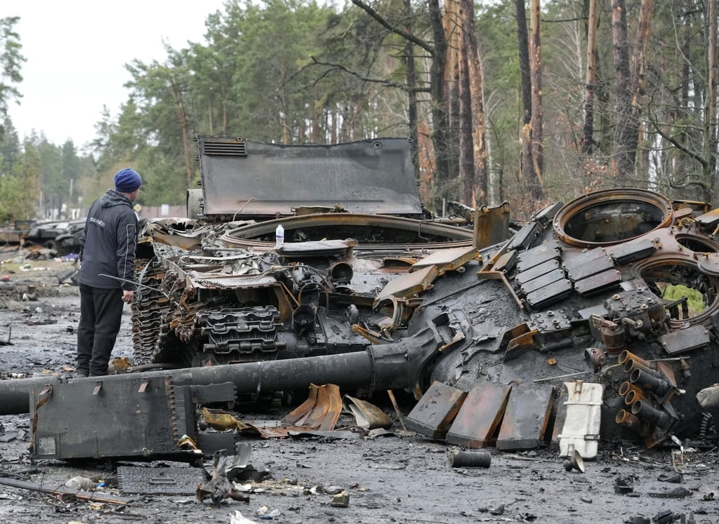 A local resident examines destroyed Russian tanks in the village of Dmytrivka, close to Kyiv, on Saturday. Photo: AP A local resident examines destroyed Russian tanks in the village of Dmytrivka, close to Kyiv, on Saturday. Photo: AP