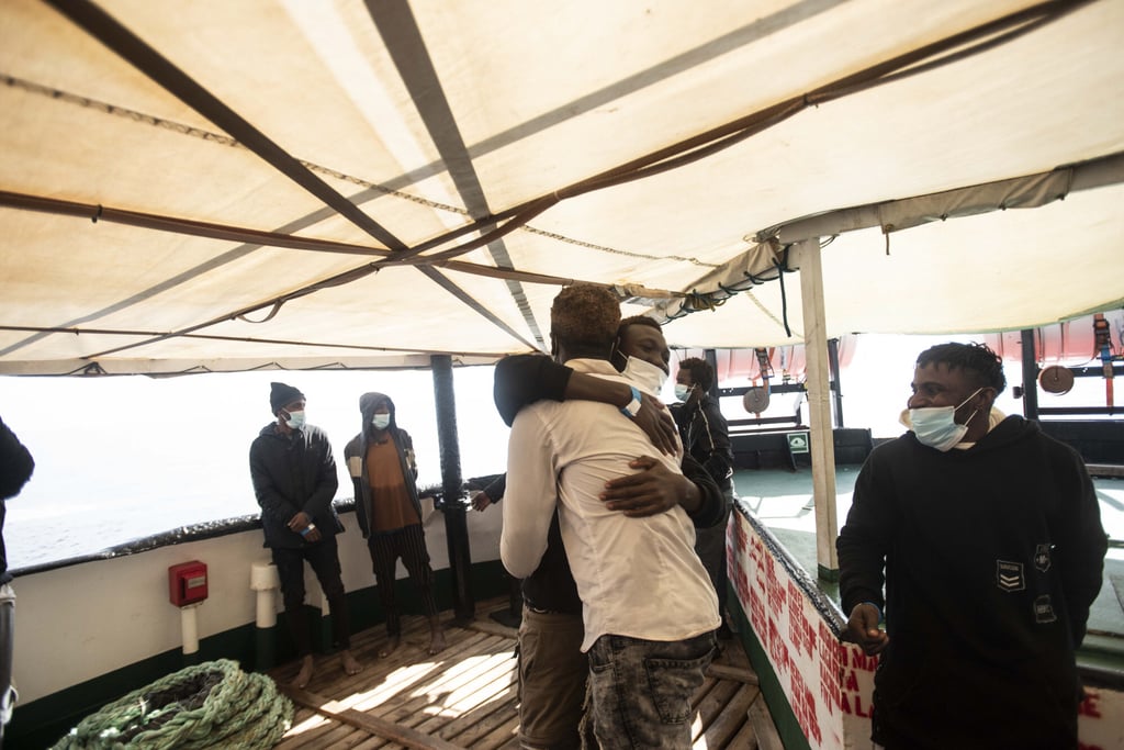 Two men hug after being rescued by Open Arms NGO 45 nautical miles from the Libyan coast on March 5, 2022. Photo: AP