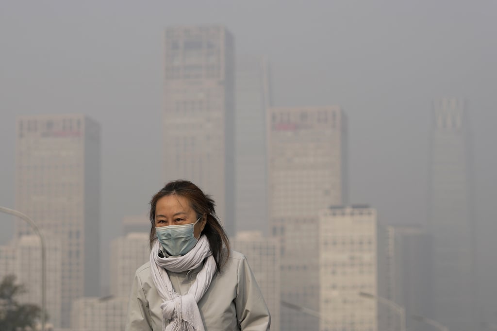 A woman in Beijing shrouded by pollution haze. File photo: AP