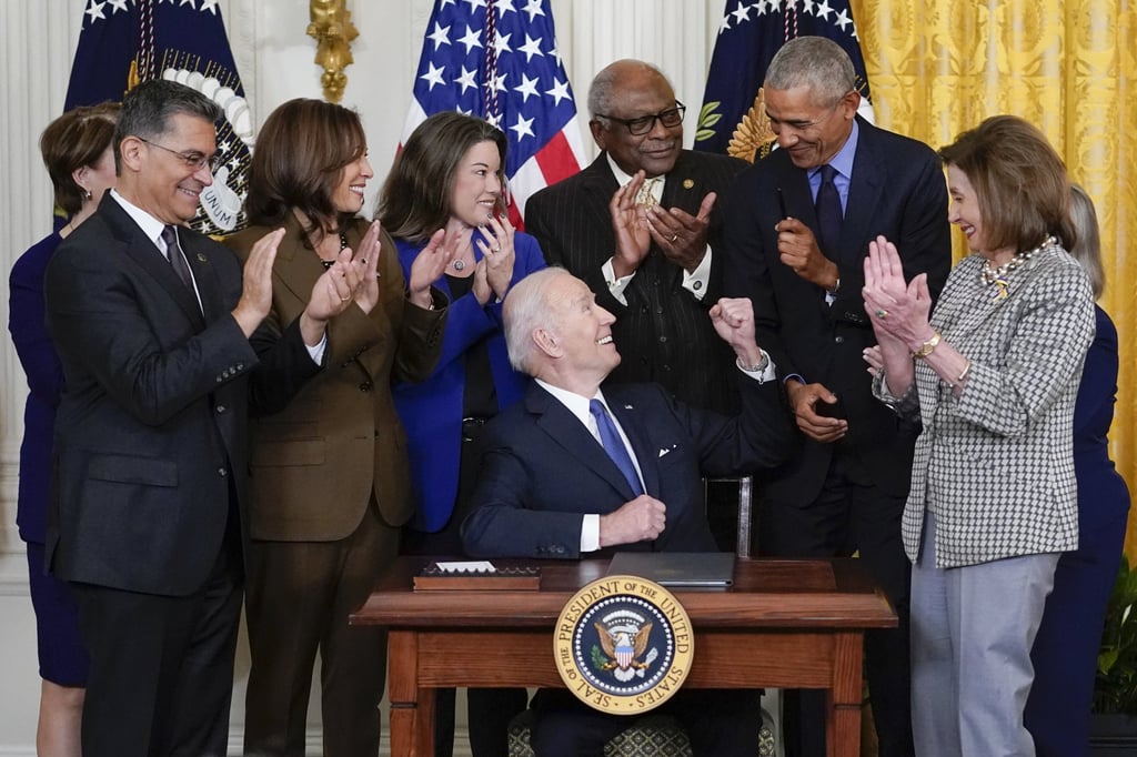 US President Joe Biden hands a pen to former president Barack Obama after signing an executive order during an event marking the 12th anniversary of the Affordable Care Act at the White House on Tuesday. Photo: AP