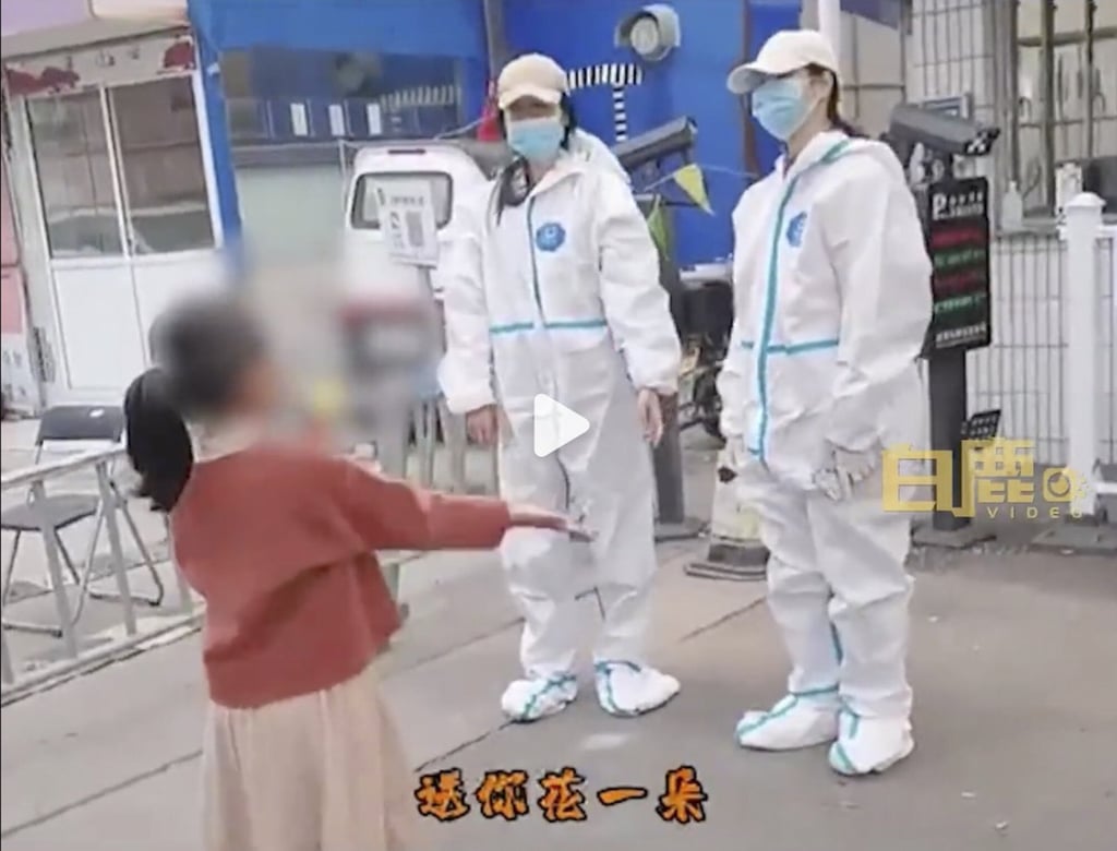 A young girl dances in front of pandemic control workers in China. Photo: Weibo