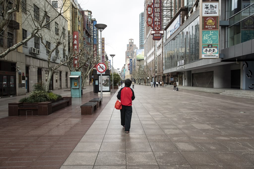 A pedestrian walks along a near-empty street in Shanghai amid a citywide lockdown to stop the spread of Covid-19. Photo: Bloomberg