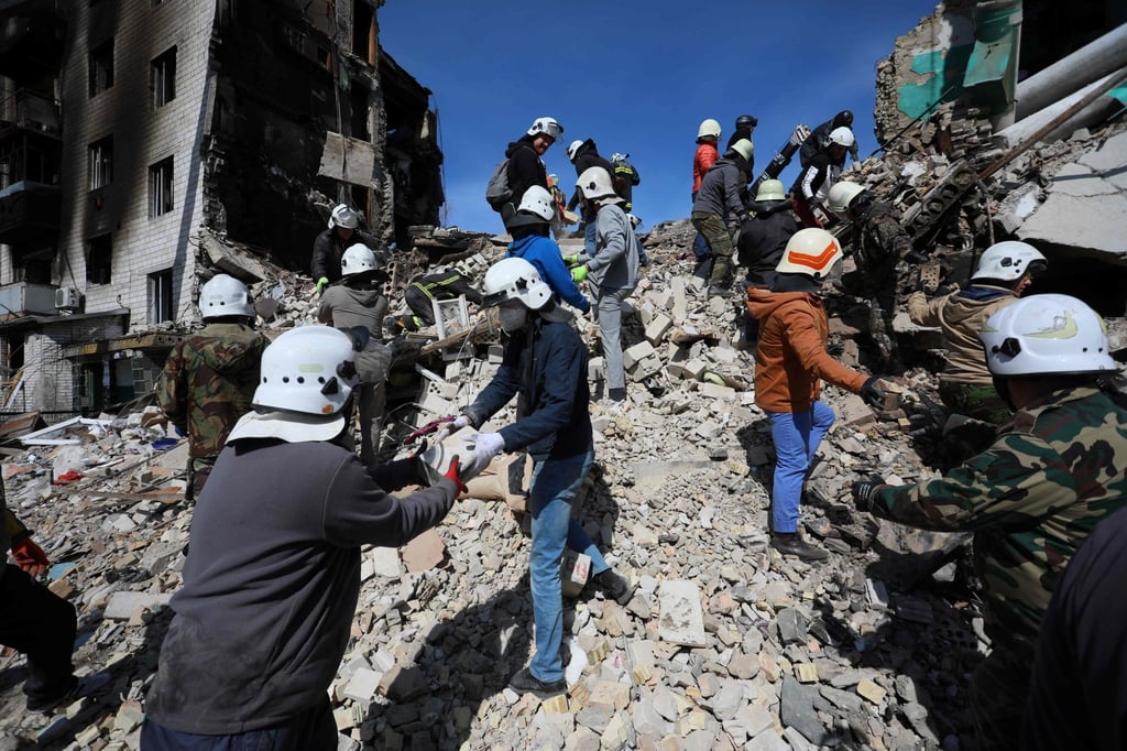 Volunteers help rescuers to remove rumbles of a damaged building in the town of Borodianka, northwest of Kyiv, on Thursday. Photo: AFP