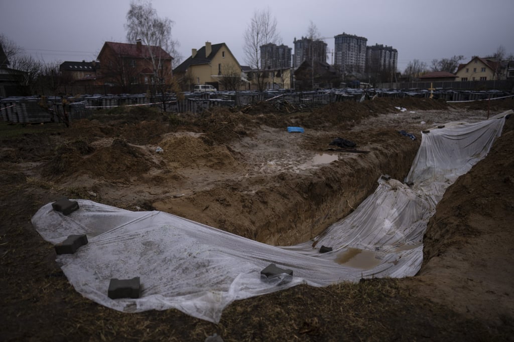 A plastic sheet covers a mass grave with civilians killed during the war against Russia in Bucha, in the outskirts of Kyiv, Ukraine, on April 10. Photo: AP