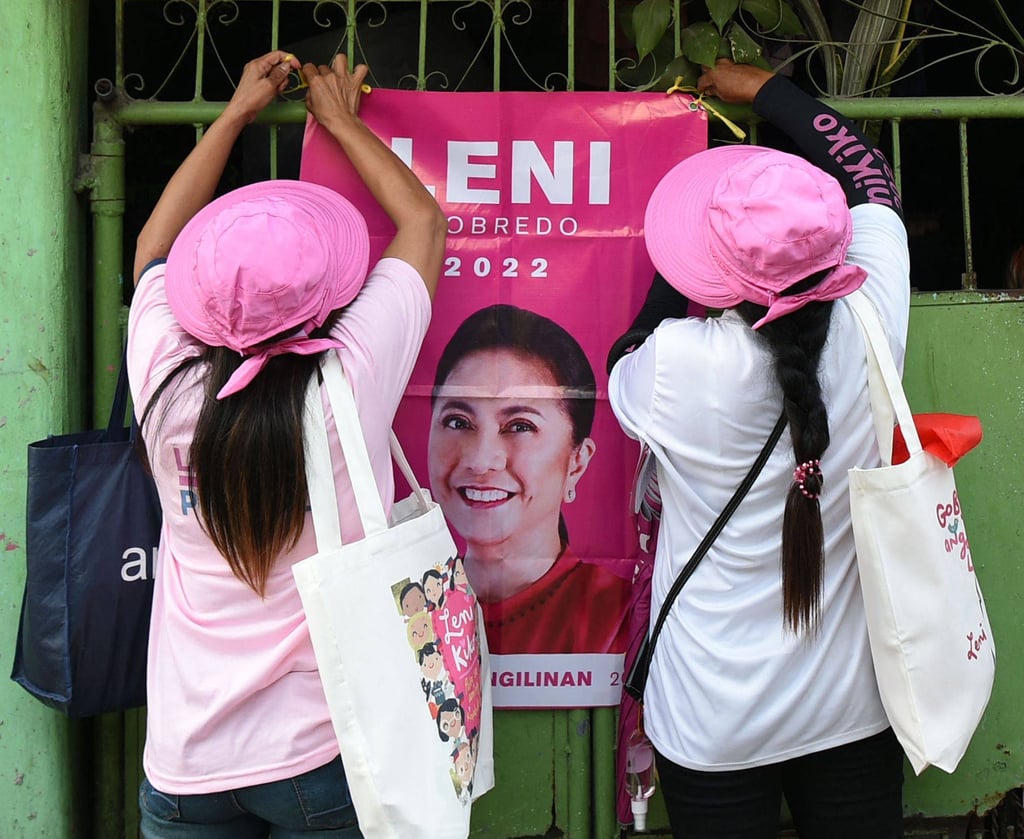 Volunteers for Leni Robredo put up a tarpaulin with Robredo’s image on a gate during a house-to-house campaign in Las Pinas, suburban Manila. Photo: AFP Volunteers for Leni Robredo put up a tarpaulin with Robredo’s image on a gate during a house-to-house campaign in Las Pinas, suburban Manila. Photo: AFP