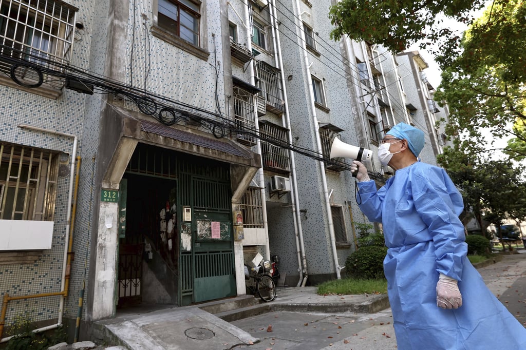 A volunteer uses a megaphone to talk to residents at a locked down apartment building in Shanghai on Tuesday, April 12, 2022. Photo: Xinhua via AP. A volunteer uses a megaphone to talk to residents at a locked down apartment building in Shanghai on Tuesday, April 12, 2022. Photo: Xinhua via AP.