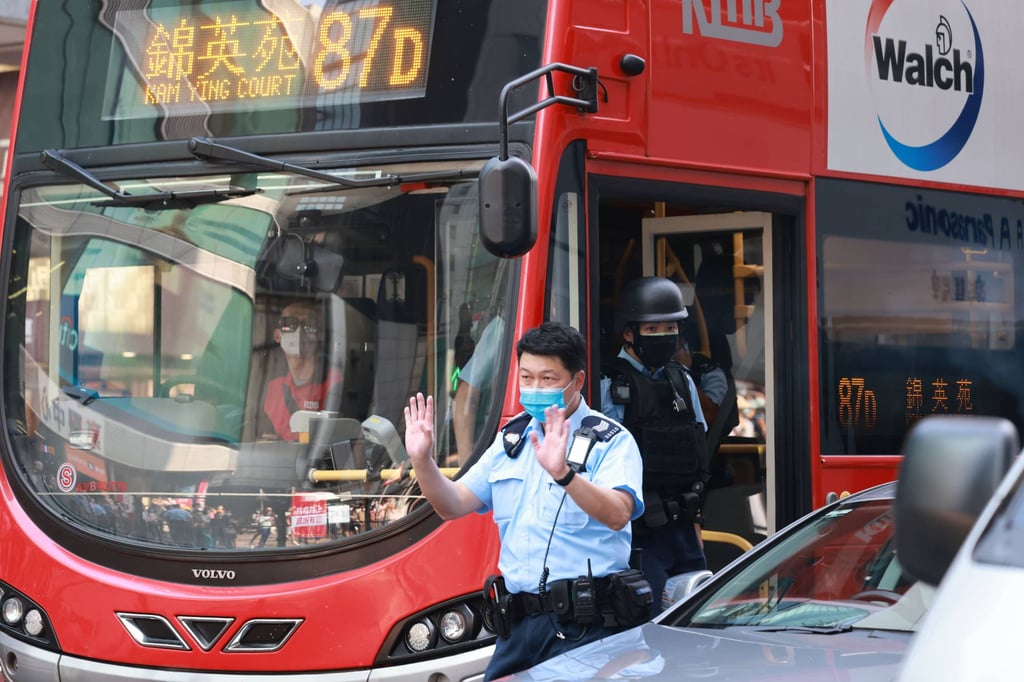 Police officers inspect a bus on Nathan Road after the robbery. Photo: May Tse Police officers inspect a bus on Nathan Road after the robbery. Photo: May Tse