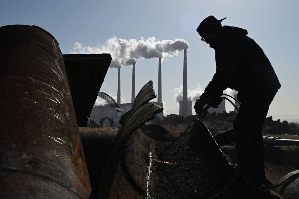 A worker using a torch to cut steel pipes near the coal-powered Datang International Zhangjiakou Power Station at Zhangjiakou, in China’s northern Hebei province. Photo: AFP A worker using a torch to cut steel pipes near the coal-powered Datang International Zhangjiakou Power Station at Zhangjiakou, in China’s northern Hebei province. Photo: AFP