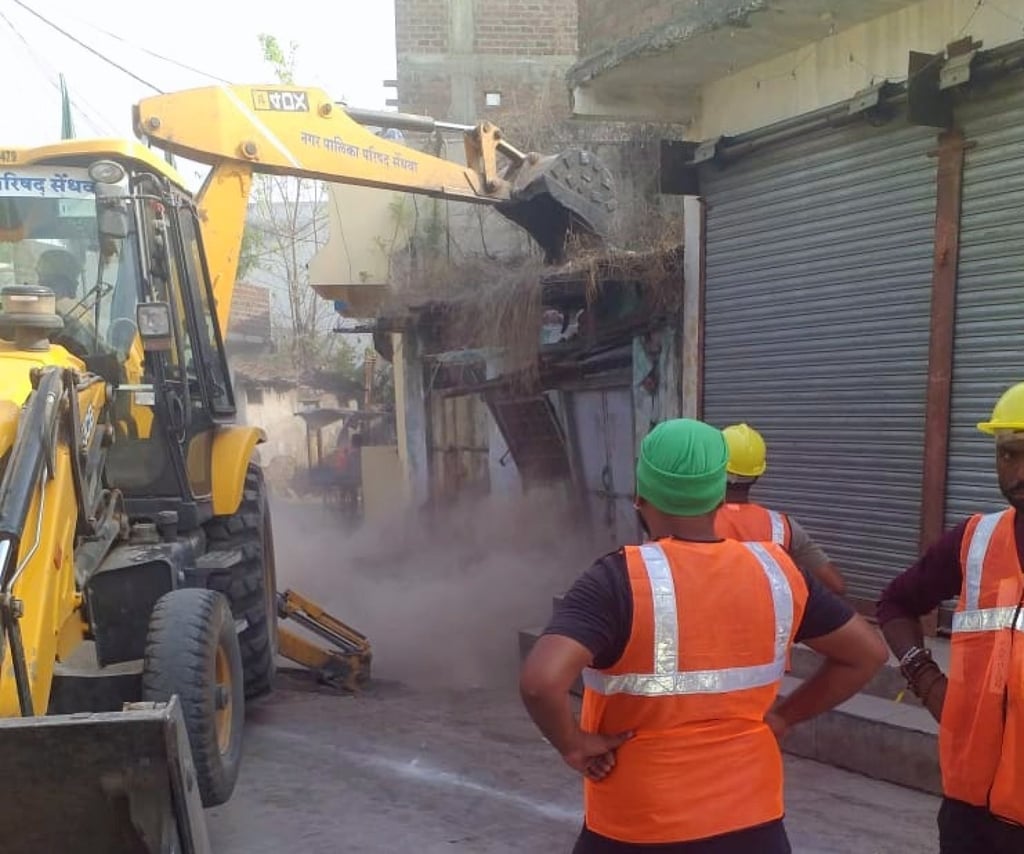 A bulldozer tears down a building in Madhya Pradesh, India, on April 11, 2022. Photo: Twitter