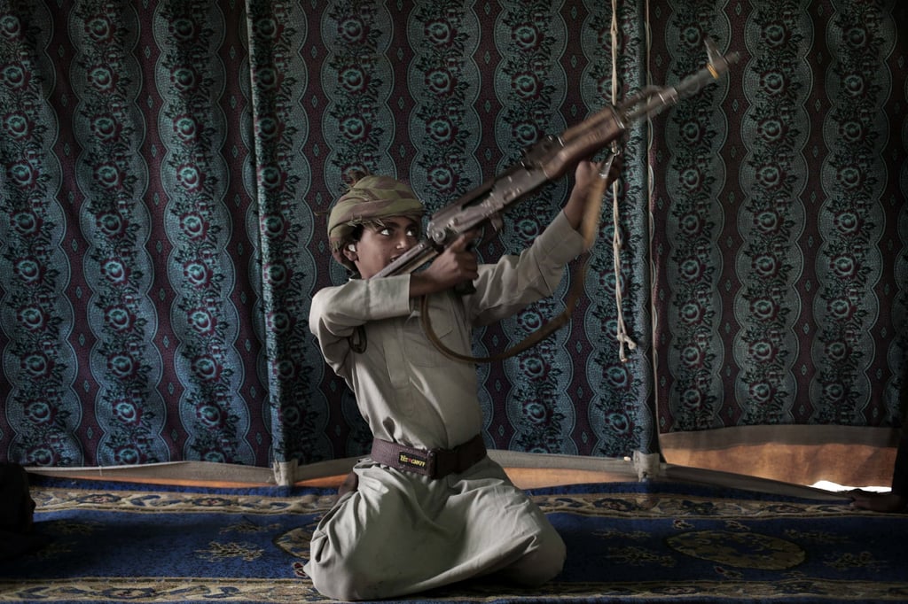 Kahlan, a 12-year-old former child soldier with Yemen’s Houthi rebels, shows how to use a weapon. Photo: AP