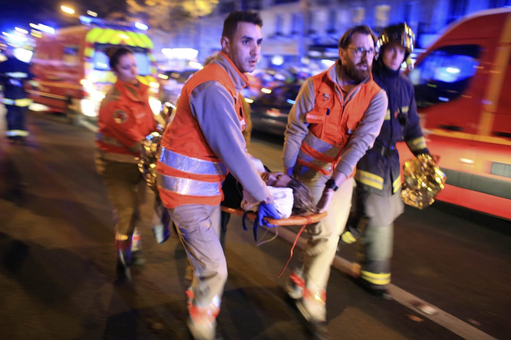 A woman is evacuated from the Bataclan concert hall after a shooting in Paris in November 2015. Photo: AP