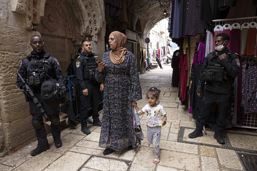 A Palestinian woman walks by Israeli security forces on guard in Jerusalem’s Old City on Tuesday. Photo: AFP