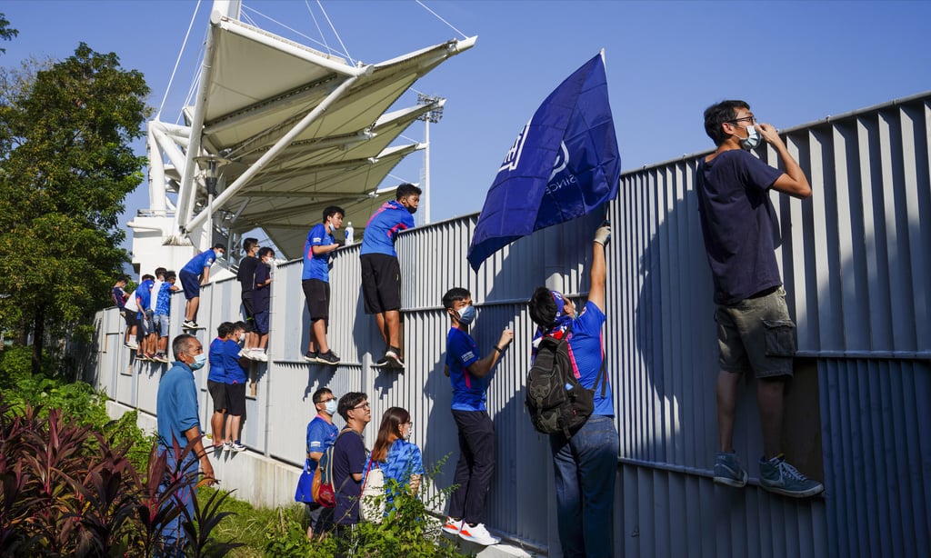 Fans try to get a glimpse of a match between Happy Valley and Kitchee from outside at the Mong Kok Stadium. Photo: Sam Tsang Fans try to get a glimpse of a match between Happy Valley and Kitchee from outside at the Mong Kok Stadium. Photo: Sam Tsang