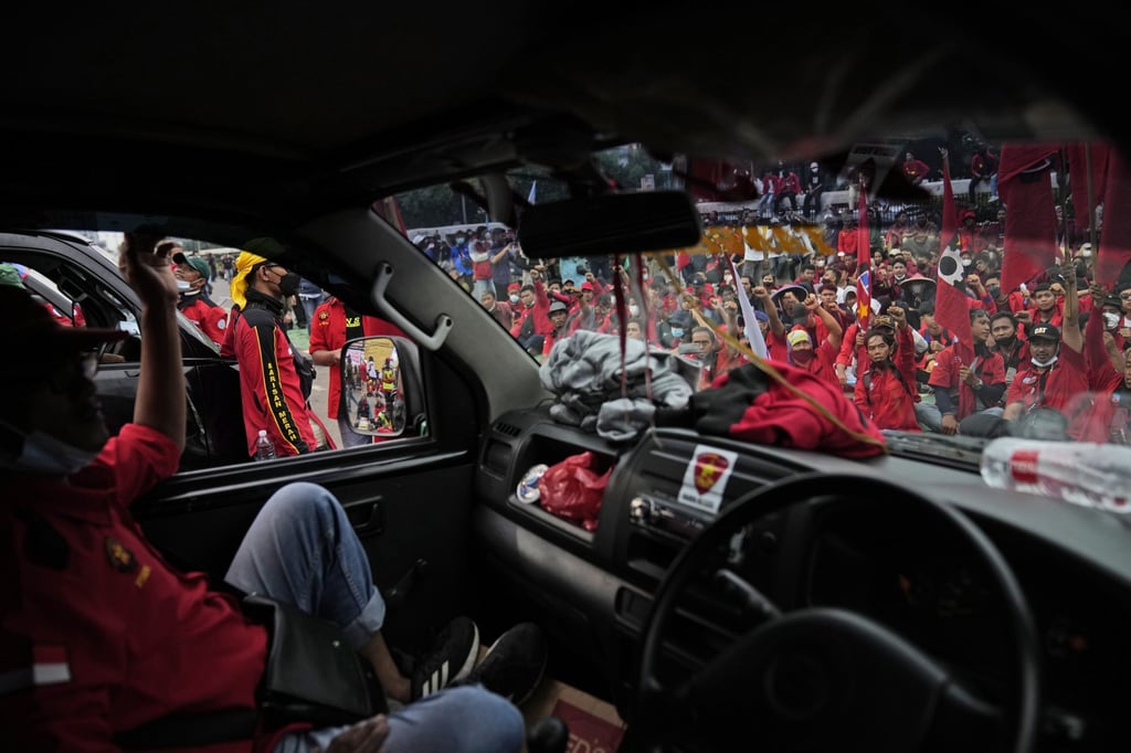 Protesters are seen shouting slogans through the windscreen of a car during a rally outside the parliament in Jakarta, Indonesia on Thursday. Photo: AP