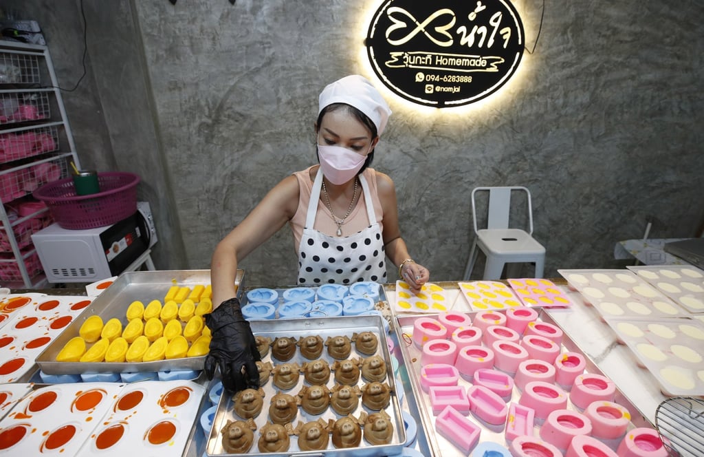 A shop owner prepares desserts that resemble Lunar New Year offerings in Bangkok, Thailand, on January 25. Photo: EPA-EFE A shop owner prepares desserts that resemble Lunar New Year offerings in Bangkok, Thailand, on January 25. Photo: EPA-EFE