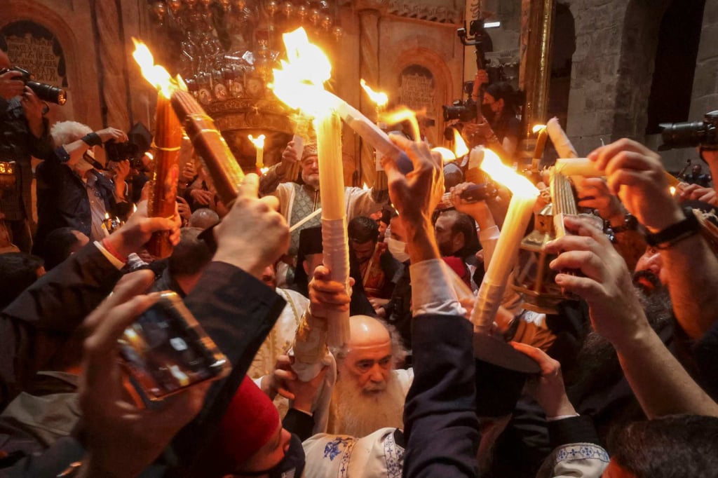 Greek Orthodox Patriarch of Jerusalem Theophilos III, centre, holds candles as Christians gather around the Edicule during the Holy Fire ceremony at Jerusalem’s Holy Sepulchre church on April 23. Photo: AFP Greek Orthodox Patriarch of Jerusalem Theophilos III, centre, holds candles as Christians gather around the Edicule during the Holy Fire ceremony at Jerusalem’s Holy Sepulchre church on April 23. Photo: AFP