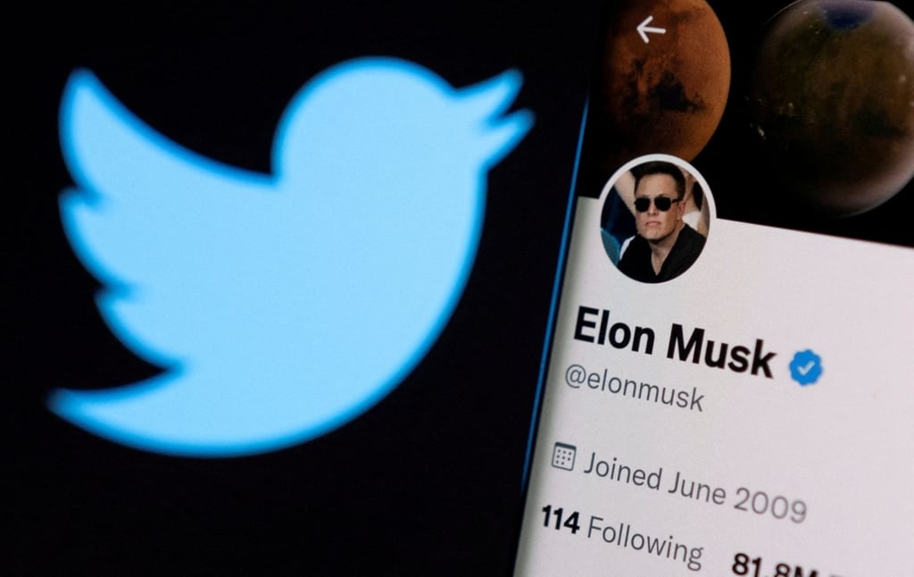 Elon Musk’s Twitter account is seen on a smartphone in front of the Twitter logo. Photo: Reuters