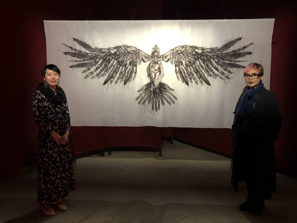 Artist Angela Su (right) and curator Freya Chou in front of “Laden Raven” (2022), a three-metre-wide hair embroidery that is part of “Arise”, the Hong Kong collateral exhibition in the 2022 Venice Biennale. Photo: t-space studio Artist Angela Su (right) and curator Freya Chou in front of “Laden Raven” (2022), a three-metre-wide hair embroidery that is part of “Arise”, the Hong Kong collateral exhibition in the 2022 Venice Biennale. Photo: t-space studio