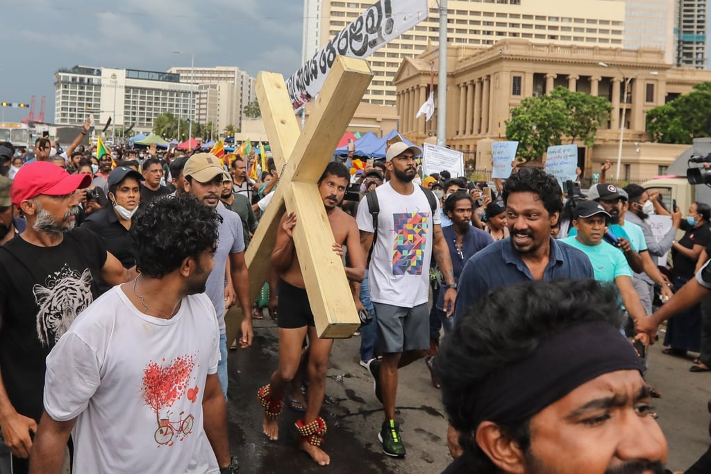A protester carries a wooden cross demanding justice for 2019 Easter Sunday attack victims during a protest in front of the president’s secretariat in Colombo, Sri Lanka, on Friday. Photo: EPA-EFE