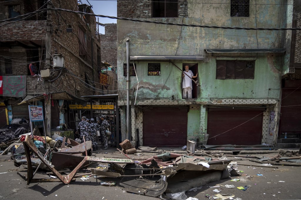 A Muslim man watches from his house in an area that saw communal violence during a Hindu religious procession in New Delhi on Saturday. Photo: AP