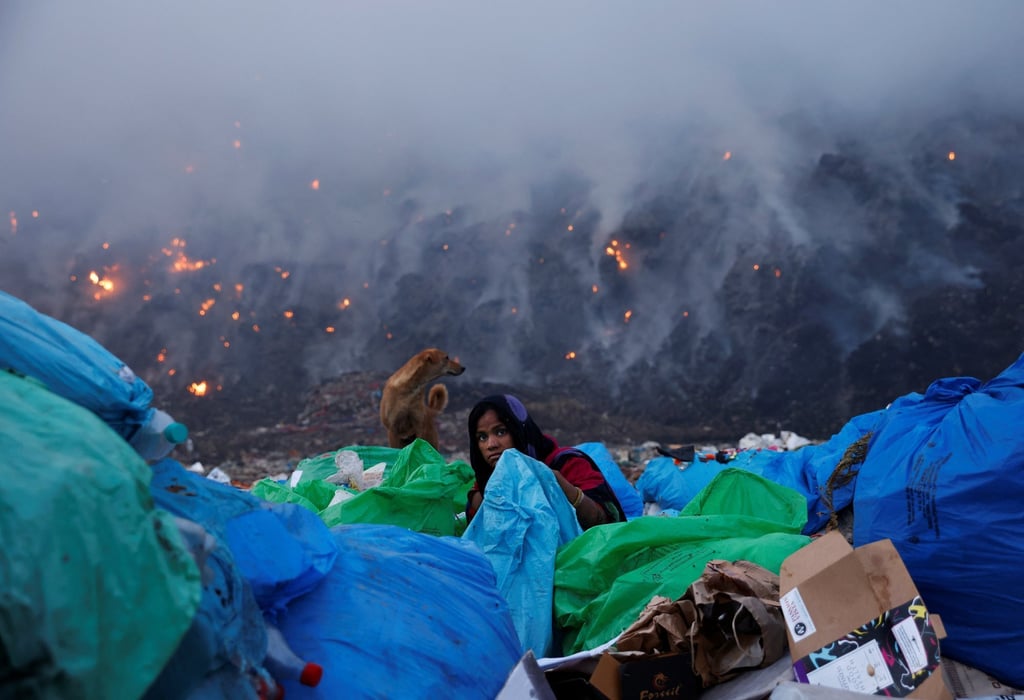 A waste collector looks for recyclable materials as smoke billows from burning garbage at the Bhalswa landfill site in New Delhi. Photo: Reuters A waste collector looks for recyclable materials as smoke billows from burning garbage at the Bhalswa landfill site in New Delhi. Photo: Reuters