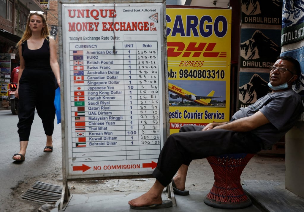 A man sits outside a money exchange in Kathmandu earlier this month. Nepal’s foreign exchange reserves have fallen below US$10 billion. Photo: Reuters