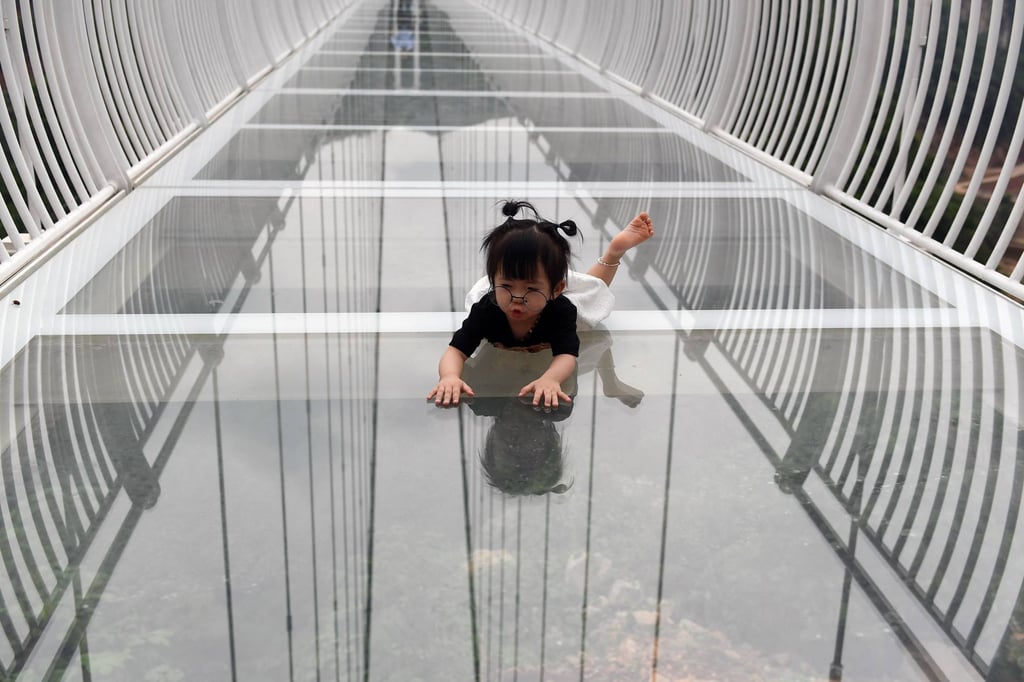 A young visitor crawls on the Bach Long glass bridge. Photo: AFP A young visitor crawls on the Bach Long glass bridge. Photo: AFP