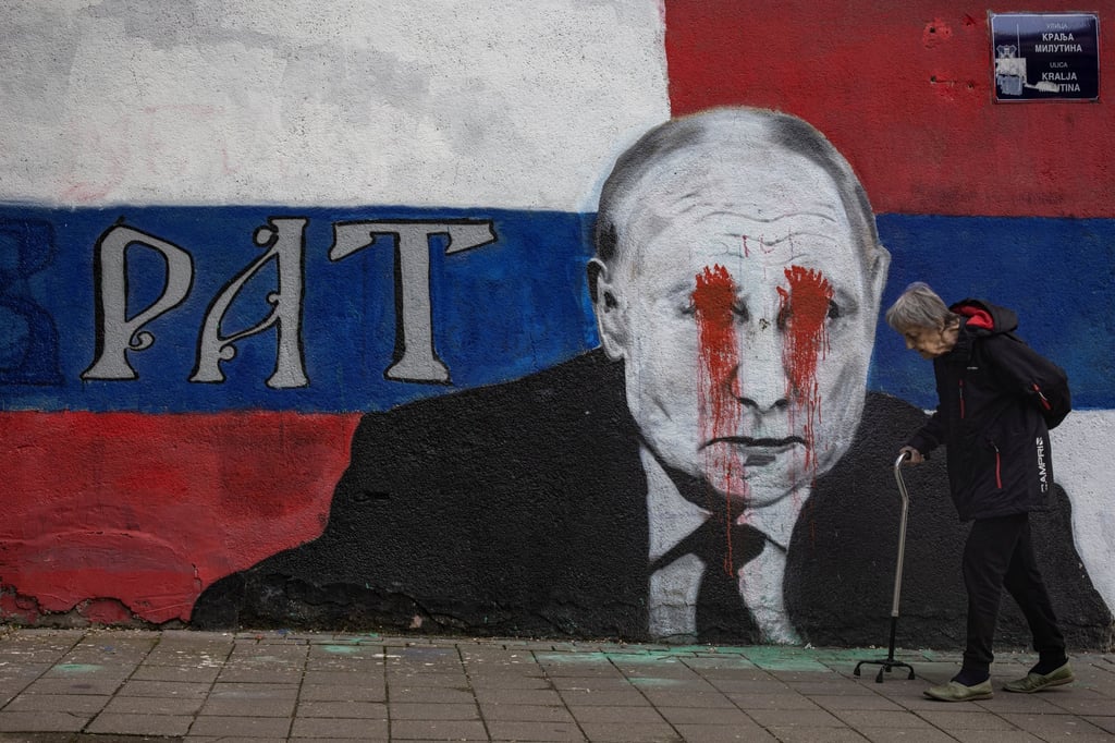 A person walks next to a mural of Russian President Vladimir Putin, which has been vandalised with red paint and the word “War” written instead of the original text reading “Brother”, in Belgrade, Serbia on Friday. Photo: Reuters A person walks next to a mural of Russian President Vladimir Putin, which has been vandalised with red paint and the word “War” written instead of the original text reading “Brother”, in Belgrade, Serbia on Friday. Photo: Reuters