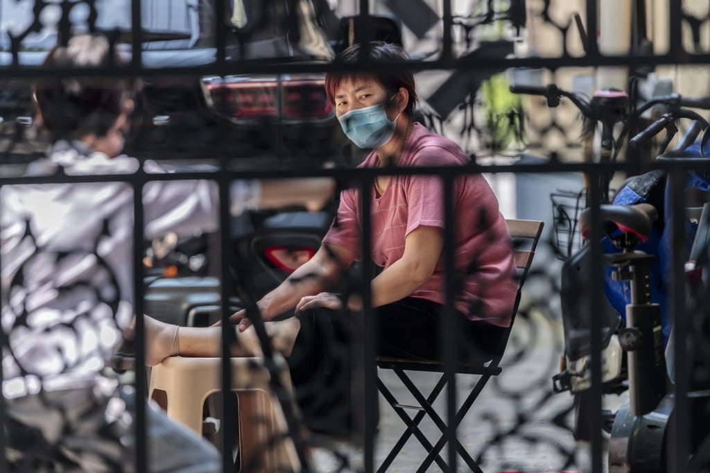 A woman in quarantine sat in front of her building in Shanghai on May 2, 2022. Photo: EPA-EFE