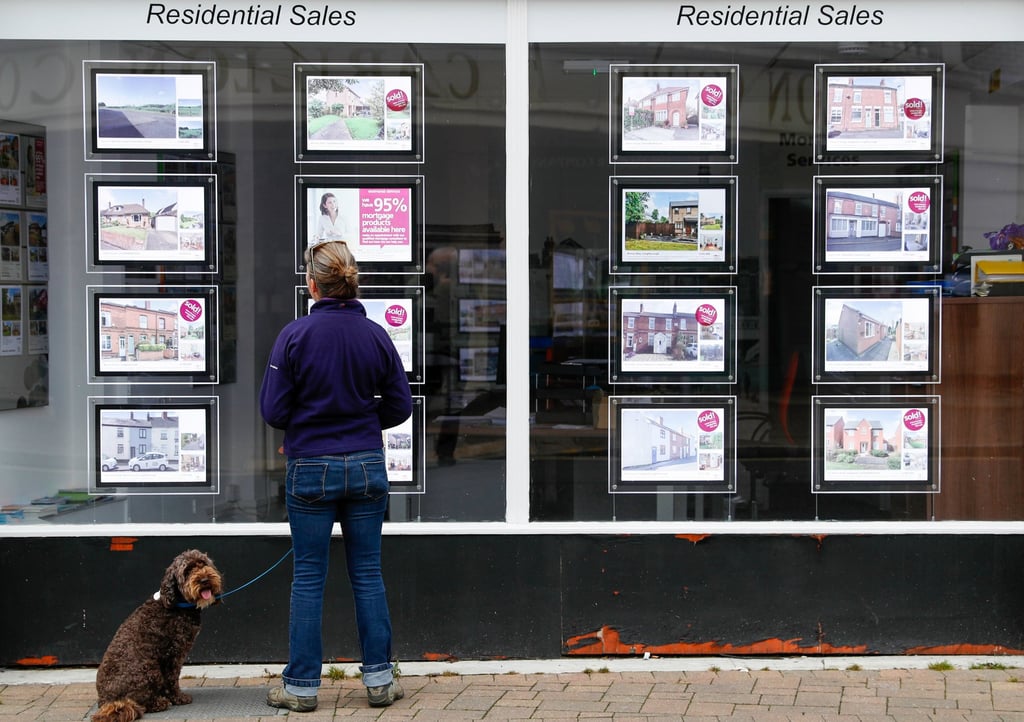 A pedestrian looks at residential sales displayed in the window of an property agent in Loughborough, UK, on July 5, 2021. Photo: Bloomberg A pedestrian looks at residential sales displayed in the window of an property agent in Loughborough, UK, on July 5, 2021. Photo: Bloomberg