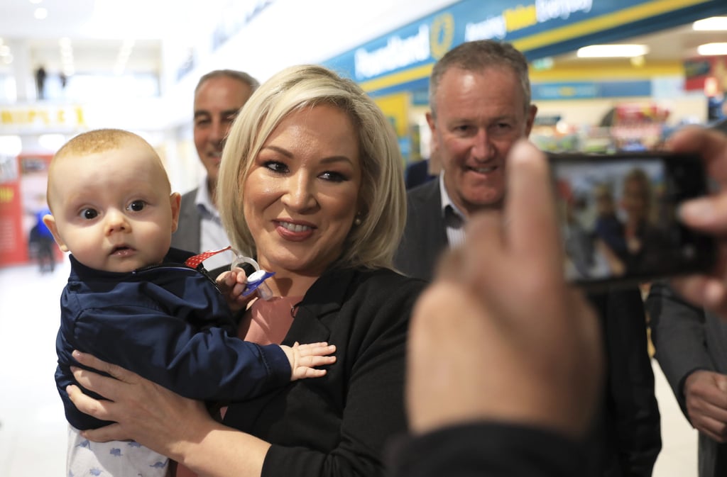 Michelle O’Neill, Sinn Fein leader in Northern Ireland, holds a child while out canvassing in Belfast, Northern Ireland on Tuesday. Photo: AP Michelle O’Neill, Sinn Fein leader in Northern Ireland, holds a child while out canvassing in Belfast, Northern Ireland on Tuesday. Photo: AP
