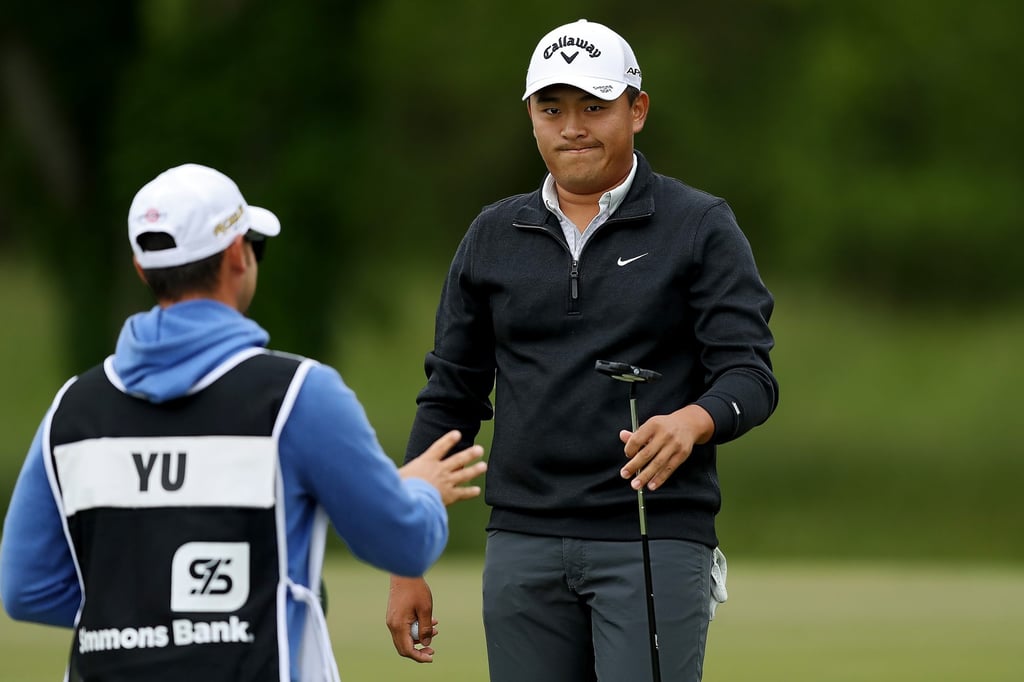Kevin Yu hands his putter to his caddie on the eighth hole during the third round of the Simmons Bank Open. Photo: AFP