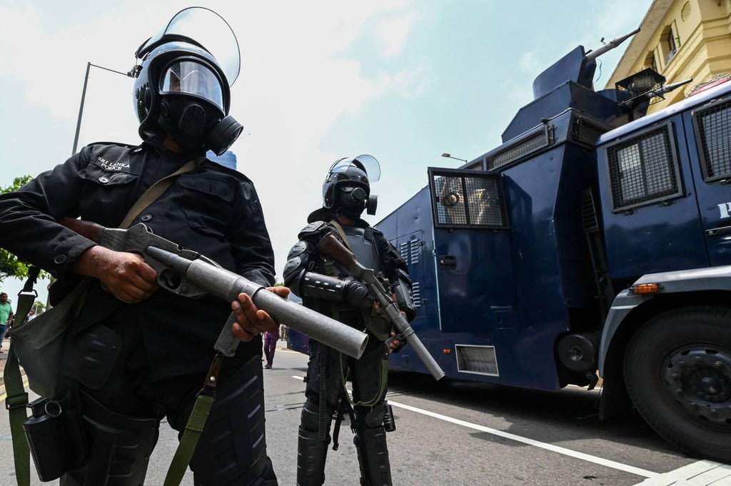 Security forces stand guard outside the president’s office in Colombo as his supporters and anti-government protesters clash on Monday. Photo: AFP
