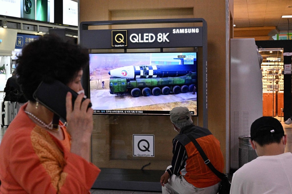 A woman walks past a television screen showing file footage of a North Korean missile test during a news broadcast in Seoul on Thursday. Photo: AFP