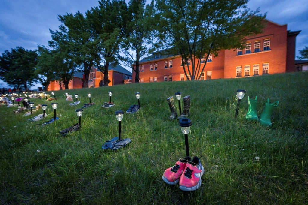 Pairs of children’s shoes and toys are seen at memorial in front of the former Kamloops Indian Residential School after the remains of 215 children, some as young as three years old, were found at the site in May 2021. Photo: Reuters