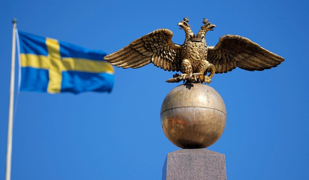 A Russian Imperial double-headed eagle is seen in front of a Sweden flag on the Czarina’s Stone in Helsinki’s Market Square in Finland on Friday. Photo: AP