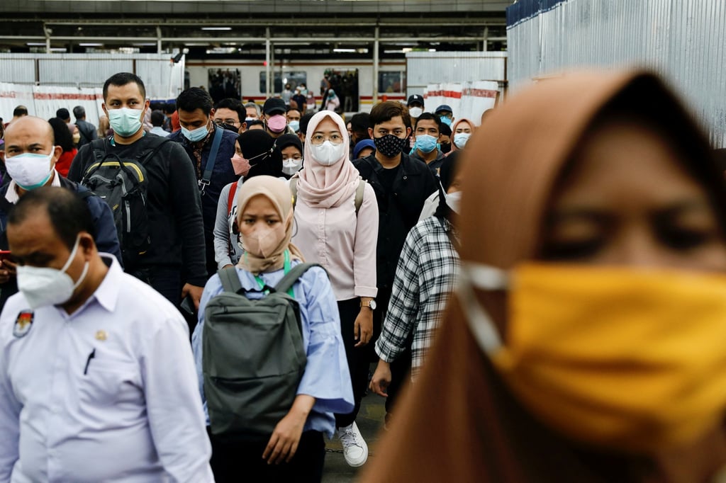 People wear protective masks walk through a platform of a railway station during the pandemic, in Jakarta, Indonesia. Indonesia announced it will drop requirements for people to mask up outdoors. Photo: Reuters