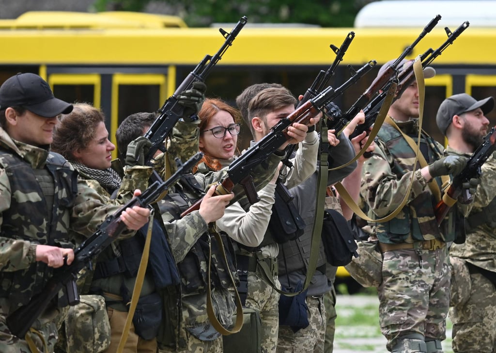 Fighters of the territorial defence unit, a support force to the regular Ukrainian army, clear their weapons after taking part in a training exercise outside Kyiv on Friday. Photo: AFP