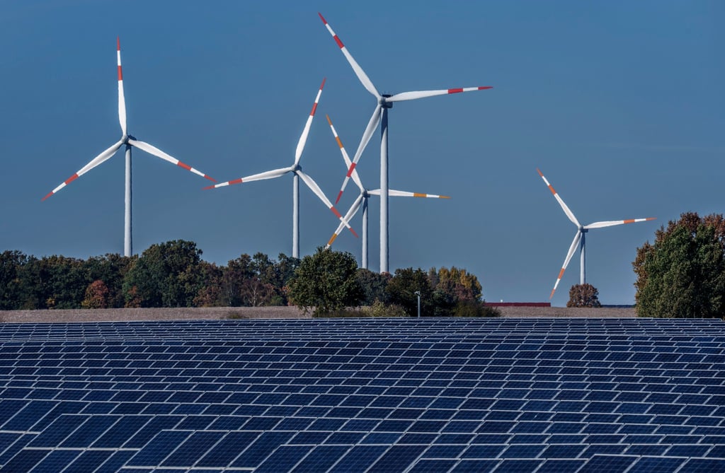 Wind turbines turn next to a solar farm. Photo: AP