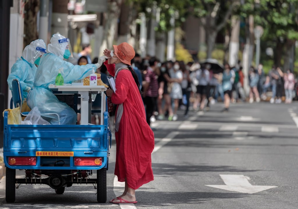 A woman takes a PCR test on the new mobile testing booth made on the cargo motorcycle, amid the ongoing Covid-19 lockdown in Shanghai on 23 May 2022. Photo: EPA-EFE