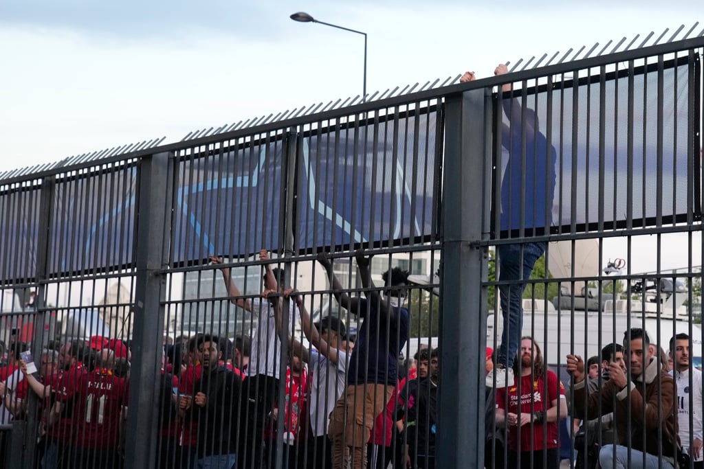 Fans climb on the fence in front of the Stade de France before the Champions League final between Liverpool and Real Madrid in Saint Denis near Paris on May 28. Photo: AP