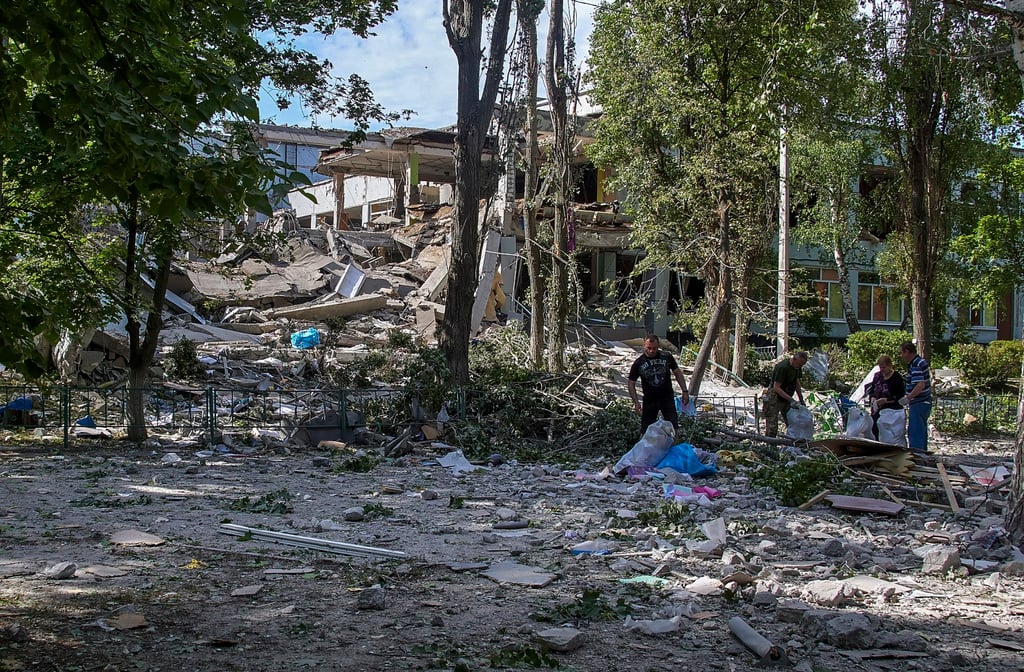 Locals clear rubble on Thursday after a rocket attack on a school near Kharkiv, Ukraine. Photo: EPA-EFE