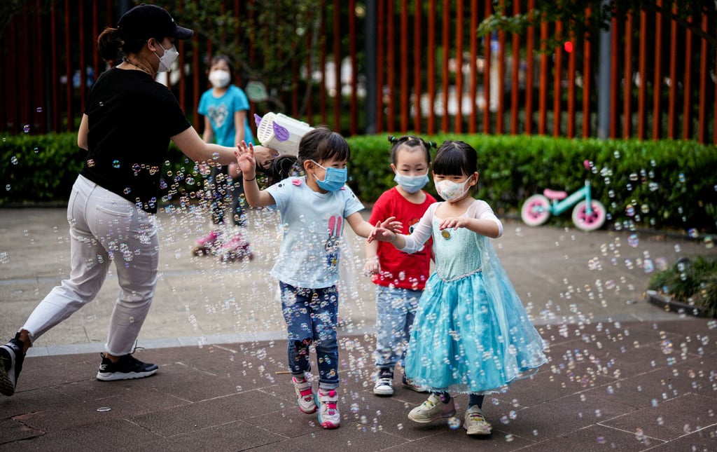 Children wearing protective face masks played amid bubbles at a park in Shanghai on May 31, 2022 on the eve of the formal end of the city’s lockdowns. Photo: Reuters.