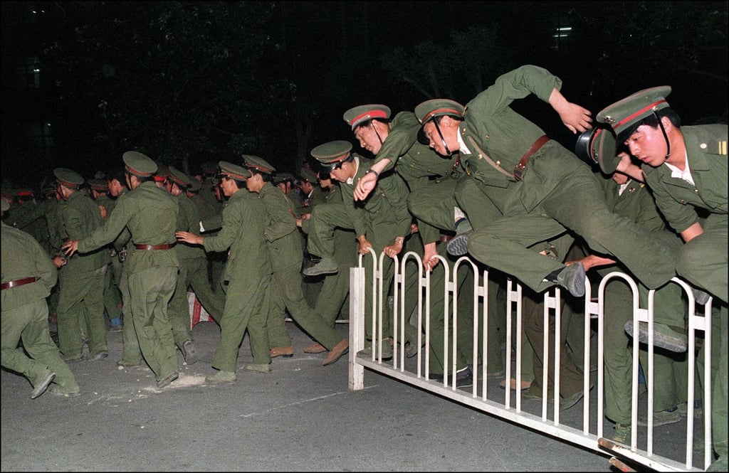 People’s Liberation Army soldiers leap over a barrier on Tiananmen Square in central Beijing during heavy clashes with people and dissident students on June 4, 1989. Photo: AFP People’s Liberation Army soldiers leap over a barrier on Tiananmen Square in central Beijing during heavy clashes with people and dissident students on June 4, 1989. Photo: AFP