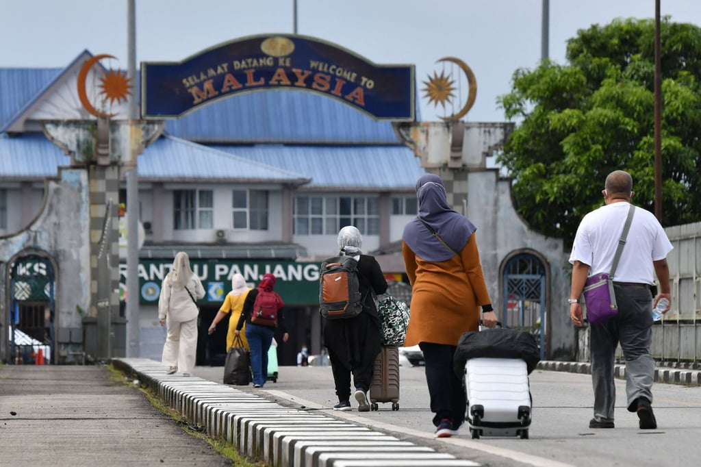 People walk towards Malaysia from southern Thailand on June 1. The two nations have re-opened their borders following a loosening of restrictions related to Covid-19. Photo: AFP